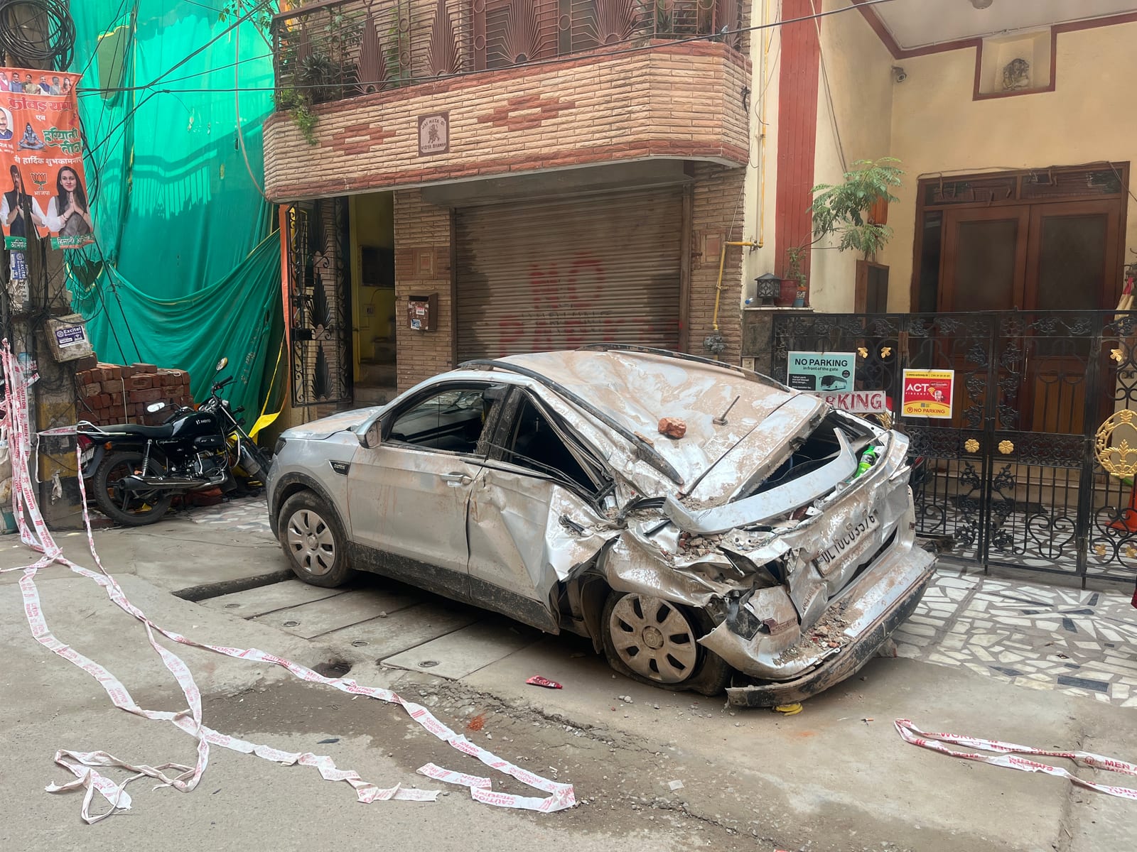 A car wreckage near the site of the building in Satya Niketan, New Delhi on Monday.
